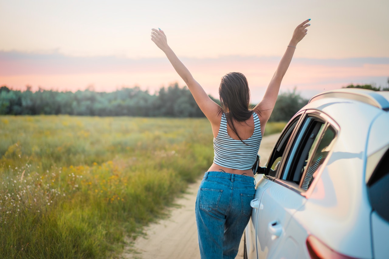 female-driver-standing-by-car